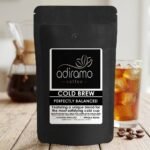 Adiramo Cold Brew Coffee bag mockup next to a glass of iced coffee and roasted coffee beans