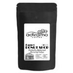 A 1lb black pouch of Adiramo Fancy Donut Shop Perfectly Balanced Morning Coffee on a wooden table near a steaming mug and pastry.